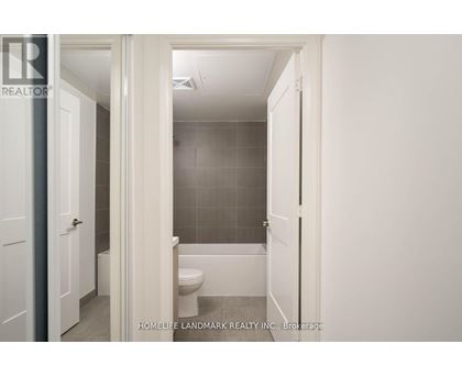 A white bathroom with a toilet and a shower stall.
