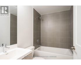 A bathroom with a white sink and a white bathtub.