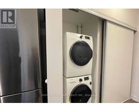 A washer and dryer are stacked on top of each other in a small space.