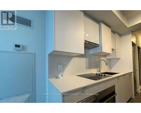 A kitchen with white cabinets and a black countertop.
