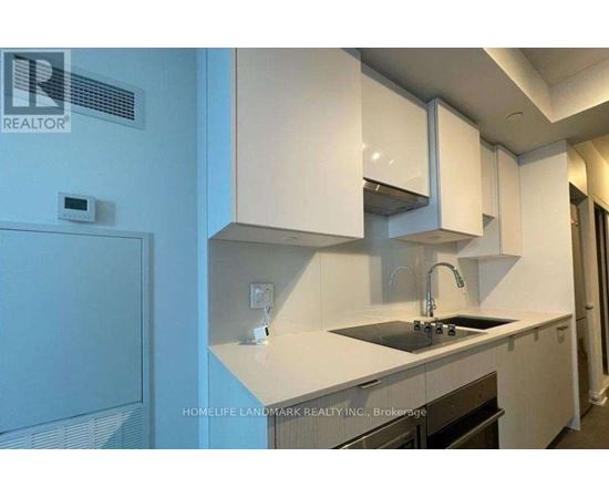A kitchen with white cabinets and a black countertop.