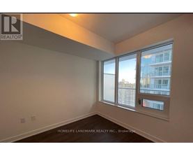 A room with a window showing a view of a building outside.