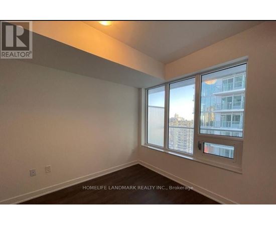 A room with a window showing a view of a building outside.