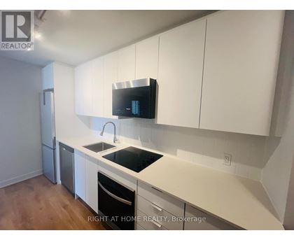 A kitchen with white cabinets and a black countertop.