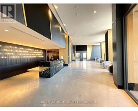 A spacious hallway with a reception desk and chairs.