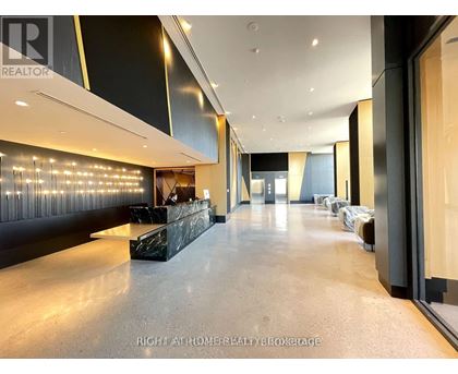 A spacious hallway with a reception desk and chairs.