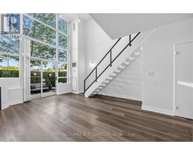 A spacious room with a staircase leading to the upper floor.