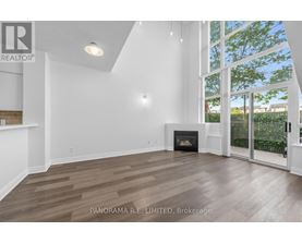 A spacious living room with wood flooring and a fireplace.