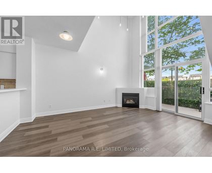 A spacious living room with wood flooring and a fireplace.