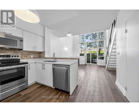A modern kitchen with stainless steel appliances and white cabinetry.