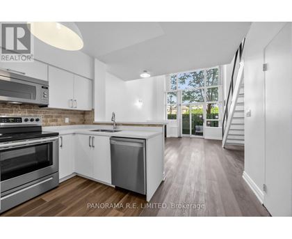 A modern kitchen with stainless steel appliances and white cabinetry.