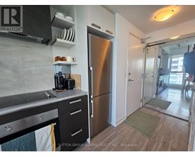 A kitchen with a stainless steel refrigerator and a stove top oven.