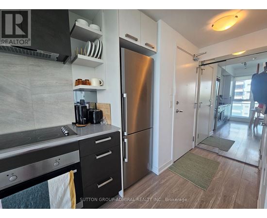A kitchen with a stainless steel refrigerator and a stove top oven.
