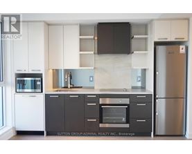 A kitchen with white cabinets and a black counter top.