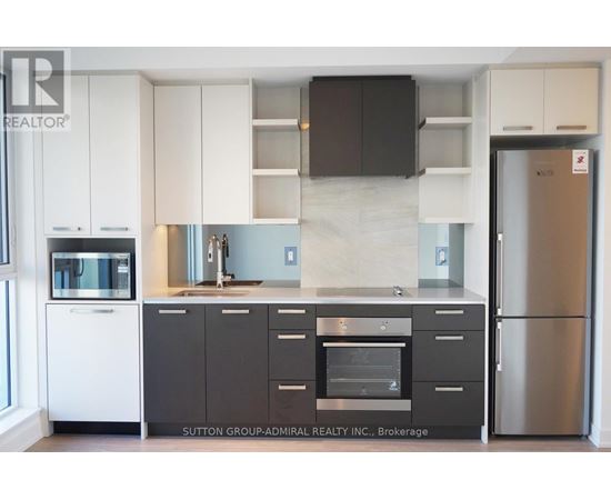 A kitchen with white cabinets and a black counter top.
