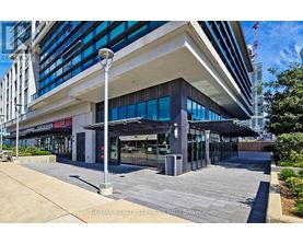 A modern building with a glass facade and a covered walkway in front.