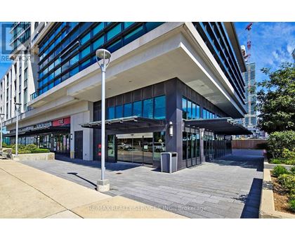 A modern building with a glass facade and a covered walkway in front.