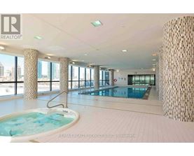 A large indoor swimming pool with a hot tub in a spacious room.