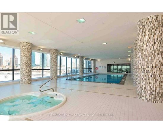 A large indoor swimming pool with a hot tub in a spacious room.