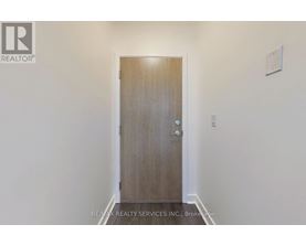 A wooden door with a handle and a small square on the wall.