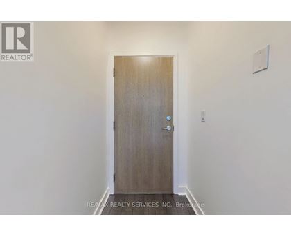 A wooden door with a handle and a small square on the wall.