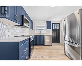 A kitchen with blue cabinets and a stainless steel refrigerator.