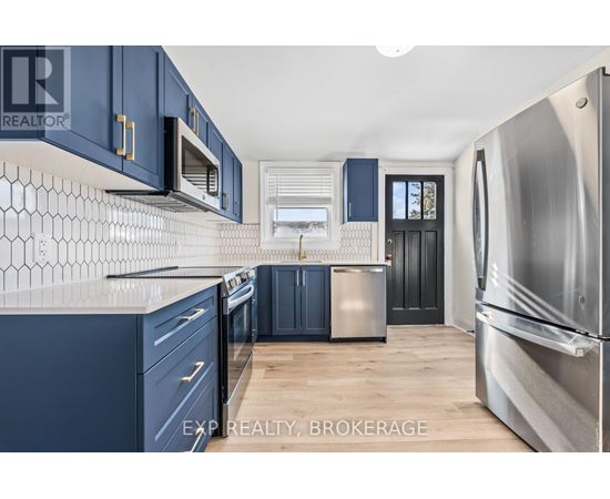 A kitchen with blue cabinets and a stainless steel refrigerator.