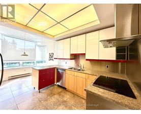 A kitchen with a sink, stove, and cabinets.