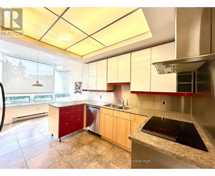 A kitchen with a sink, stove, and cabinets.