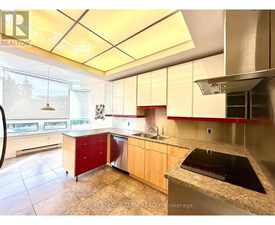 A kitchen with a sink, stove, and cabinets.