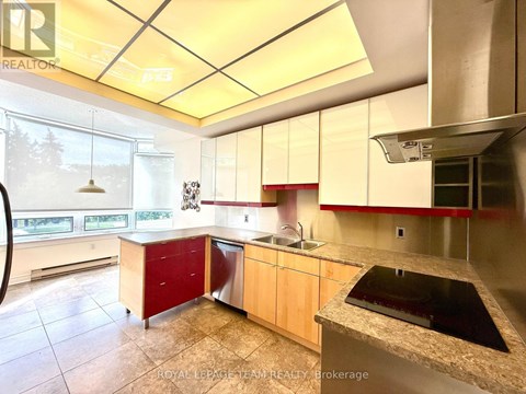A kitchen with a sink, stove, and cabinets.