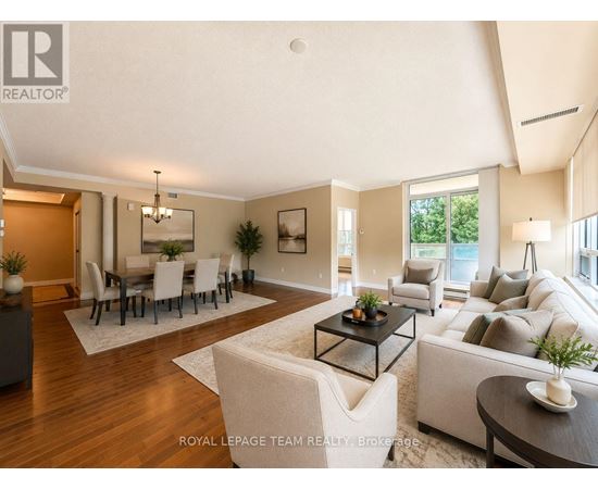 A well-lit, spacious living room with a dining area in the background.