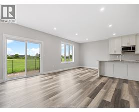 A spacious room with wooden flooring and white walls.