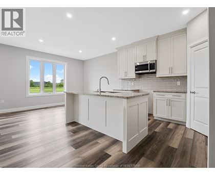 A kitchen with white cabinets and a wooden floor.