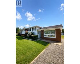 A house with a well-maintained lawn and a clear sky.