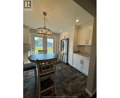 A kitchen with a table and chairs.