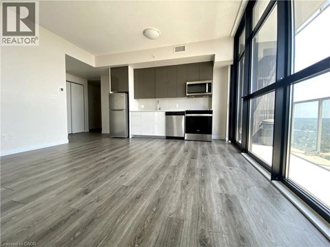 A spacious kitchen with a refrigerator, oven, and microwave.