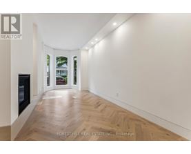 A long hallway with wood floors and white walls.