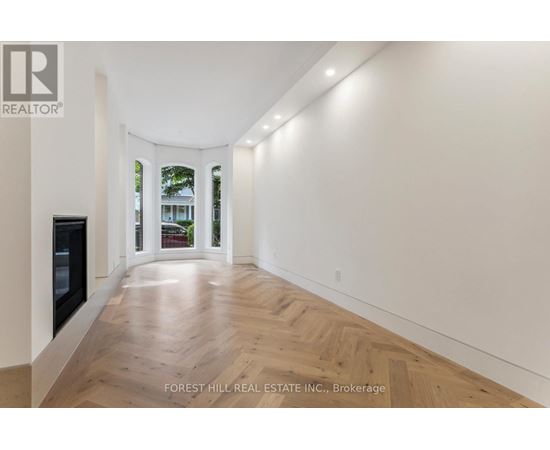 A long hallway with wood floors and white walls.