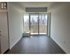 A room with a view of the city skyline through a large window.