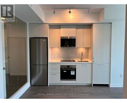 A modern kitchen with white cabinets and stainless steel appliances.