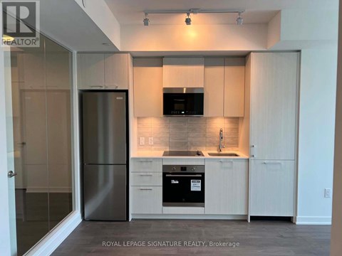 A modern kitchen with white cabinets and stainless steel appliances.