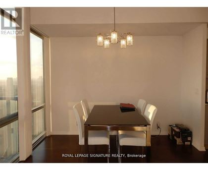 A dining room with a table and chairs.