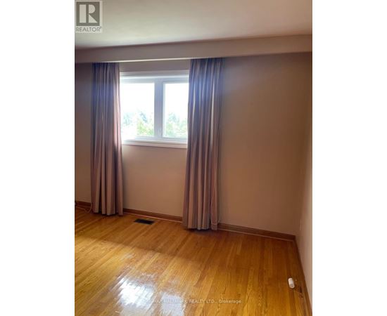 A room with a window and curtains.