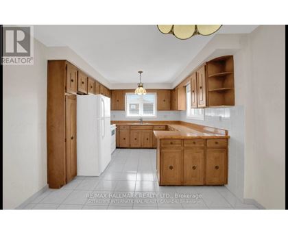 A kitchen with wooden cabinets and a white refrigerator.