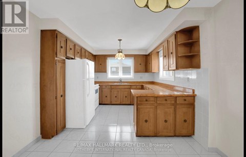 A kitchen with wooden cabinets and a white refrigerator.
