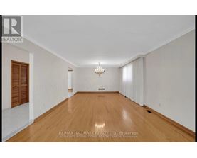 A spacious room with wooden floors and a chandelier.