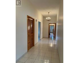A hallway with a chandelier and a door on the right.