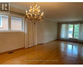 A large, well-lit room with a chandelier and hardwood floors.