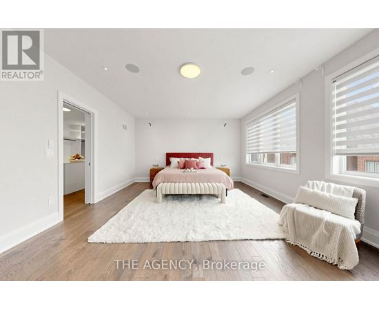 A bedroom with a red bed and a white rug.